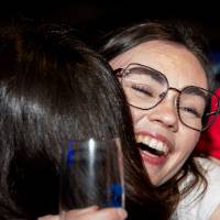 Grad smiles hugging friend at Toast